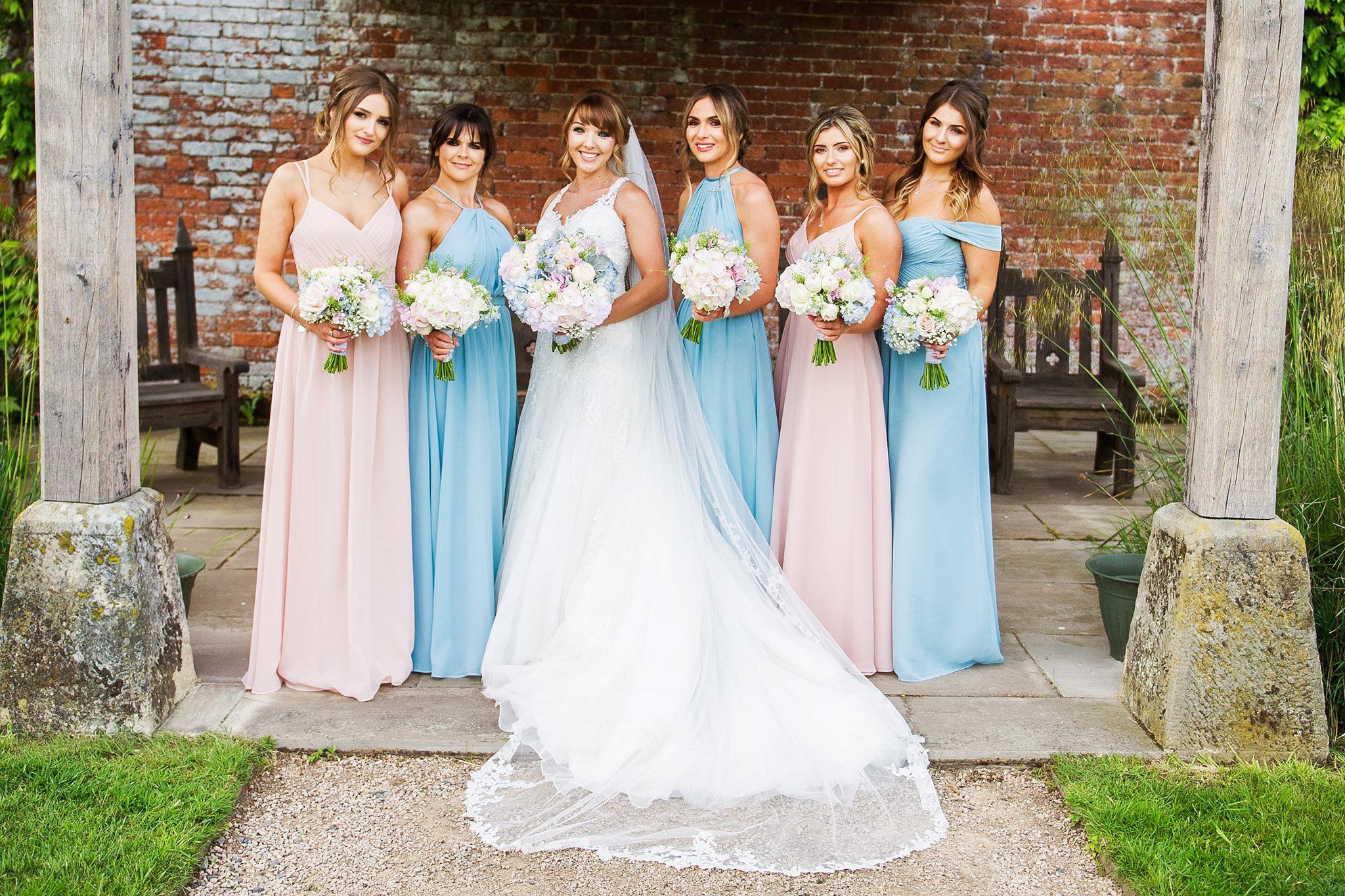 Bridal party outside holding bouquets of flowers