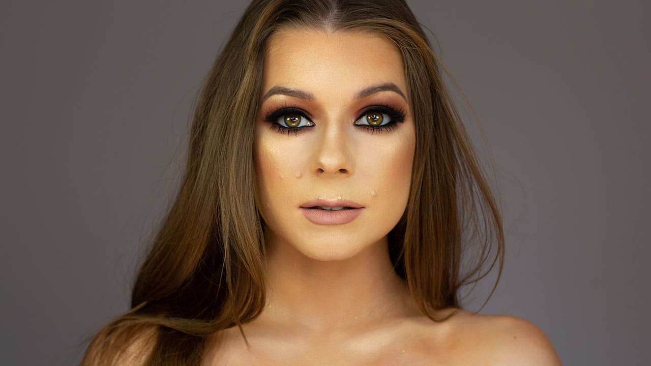 A woman with amazing makeup looking into the camera